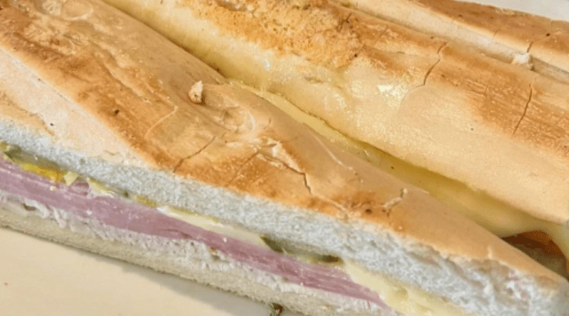 clásico sándwich cubano del restaurante Versailles, elaborado con pan cubano, jamón, cerdo, queso suizo y pepinillos.